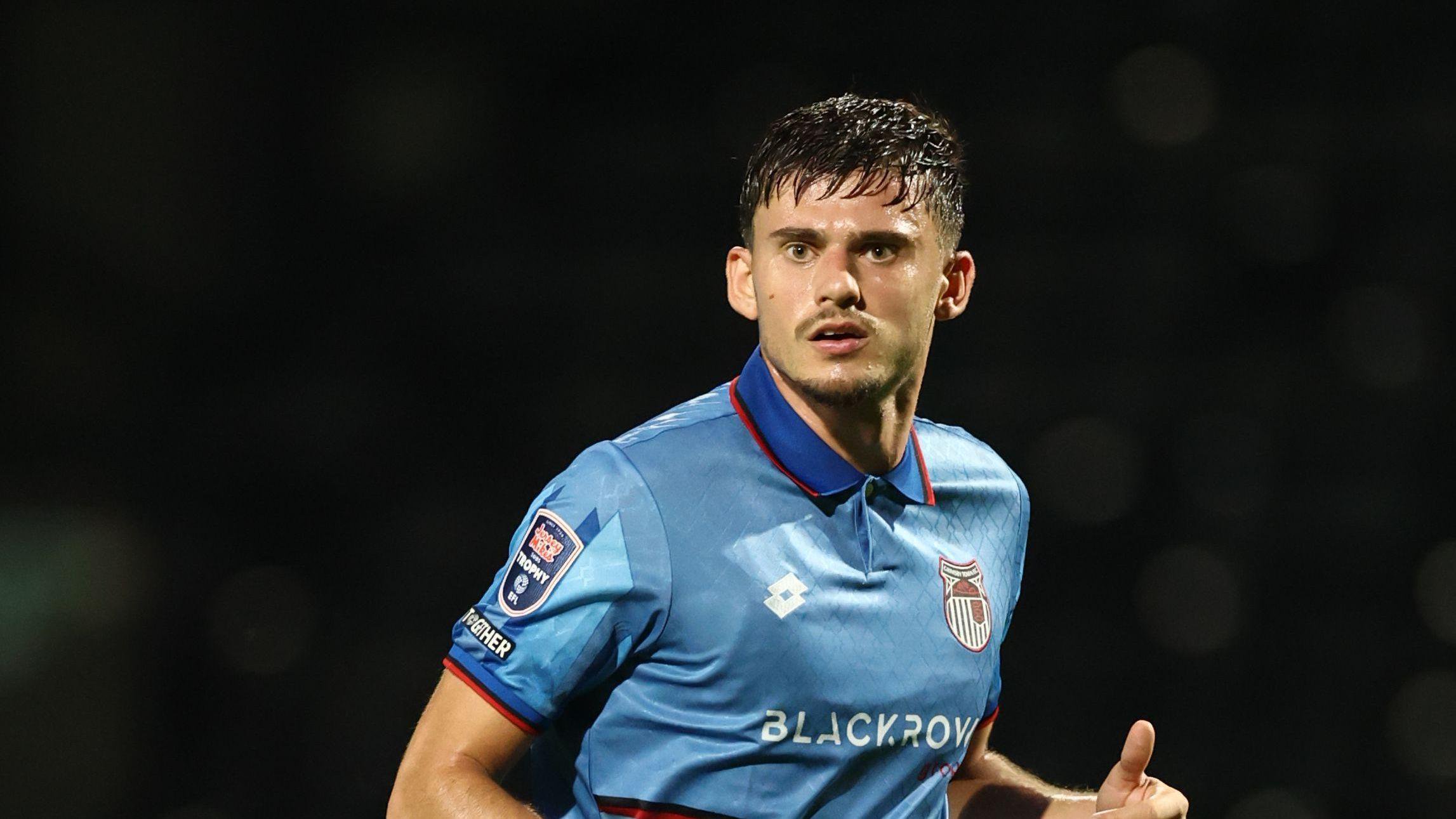 Edon Pruti playing for Grimsby Town at night in a blue away kit