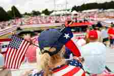 Mandy Wettstein of Chesapeake wears an American flag and Texas flag in her hat while waiting for the start of a rally for former President Donald Trump at Greenbrier Farms in Chesapeake, Virginia, on June 28, 2024. (Billy Schuerman / The Virginian-Pilot)