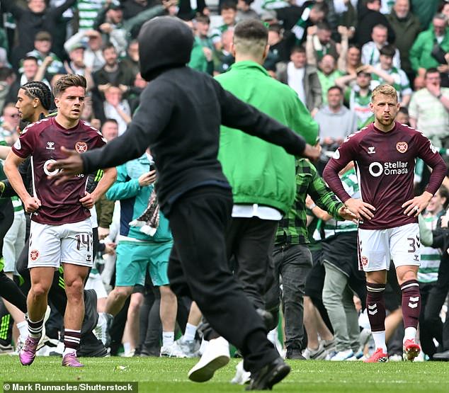 Cammy Devlin (left) and Stephen Kingsley are devastated as Celtic fans storm the pitch