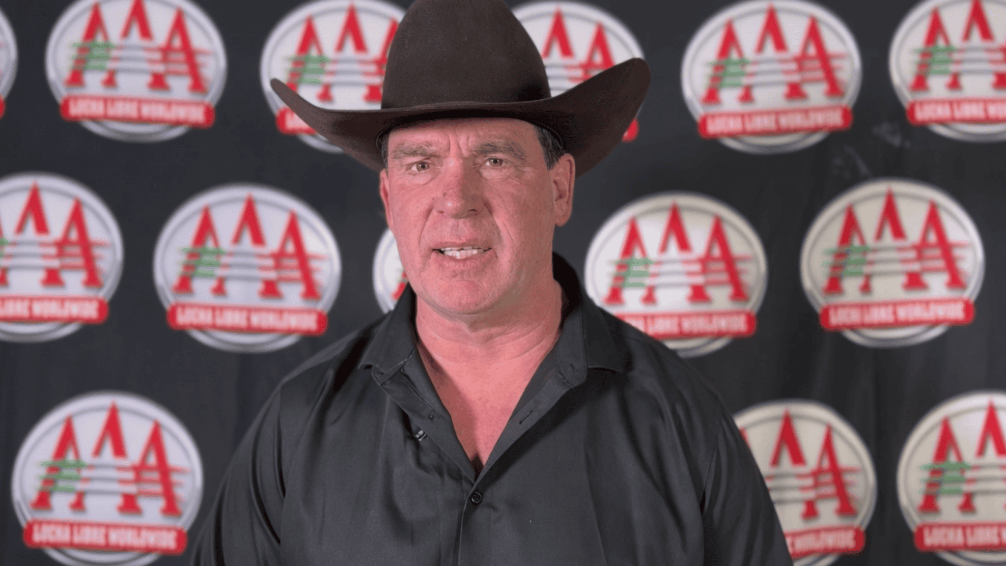 JBL in a cowboy hat in front of an AAA logo backdrop