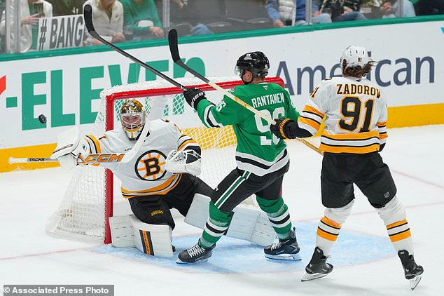 Dallas Stars right wing Mikko Rantanen, center, attacks against Boston Bruins goaltender Jeremy Swayman, left, and defenseman Nikita Zadorov during the third period of an NHL hockey game Tuesday, Oct. 20, 2026, in Dallas. (AP Photo/Julio Cortez)