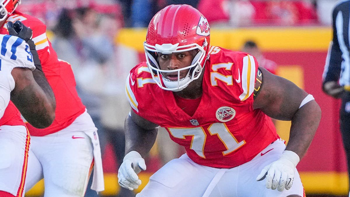 Josh Simmons, Kansas City Chiefs offensive tackle, stands on the field during a game.