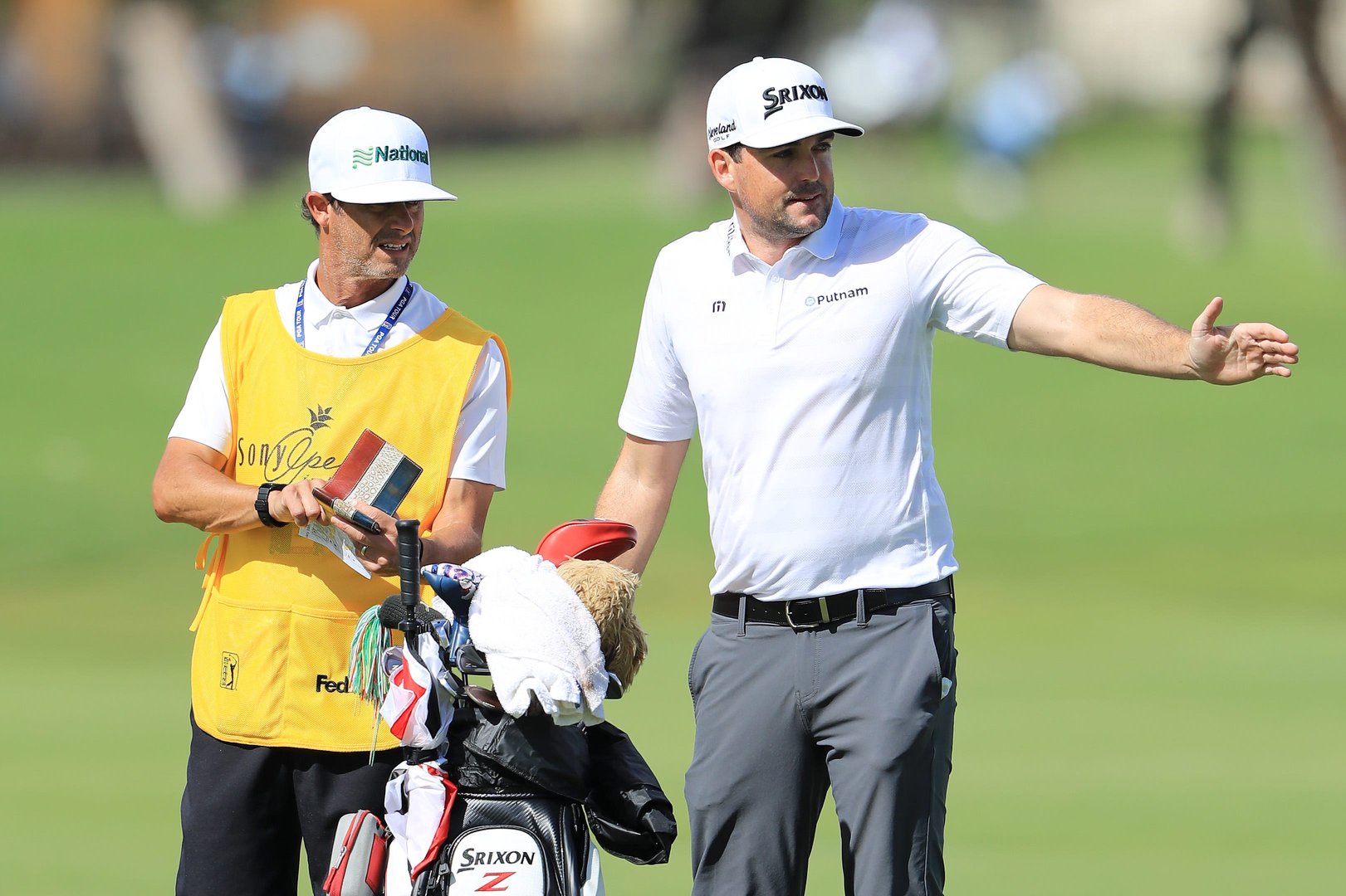 Keegan Bradley talks with his caddie Steve 
