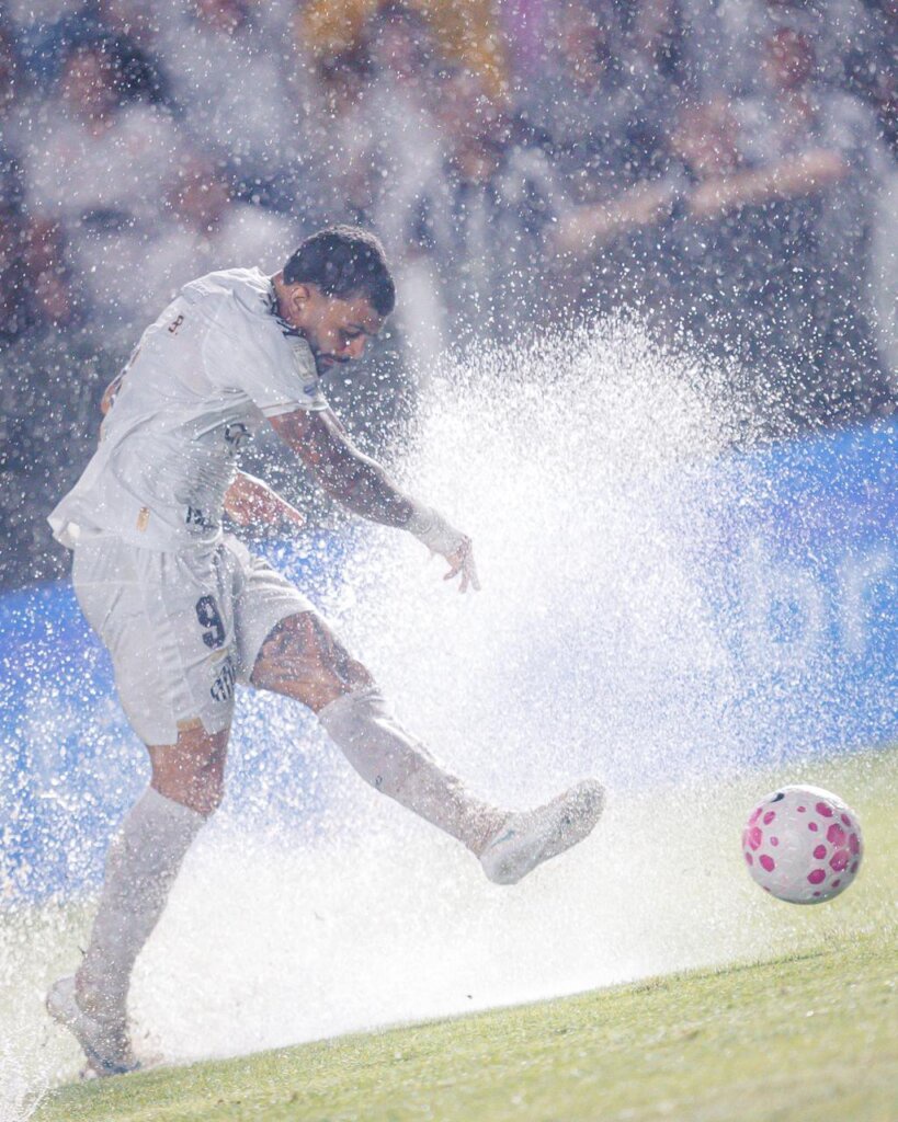Jogador do Santos em campo sob forte chuva na Vila Belmiro