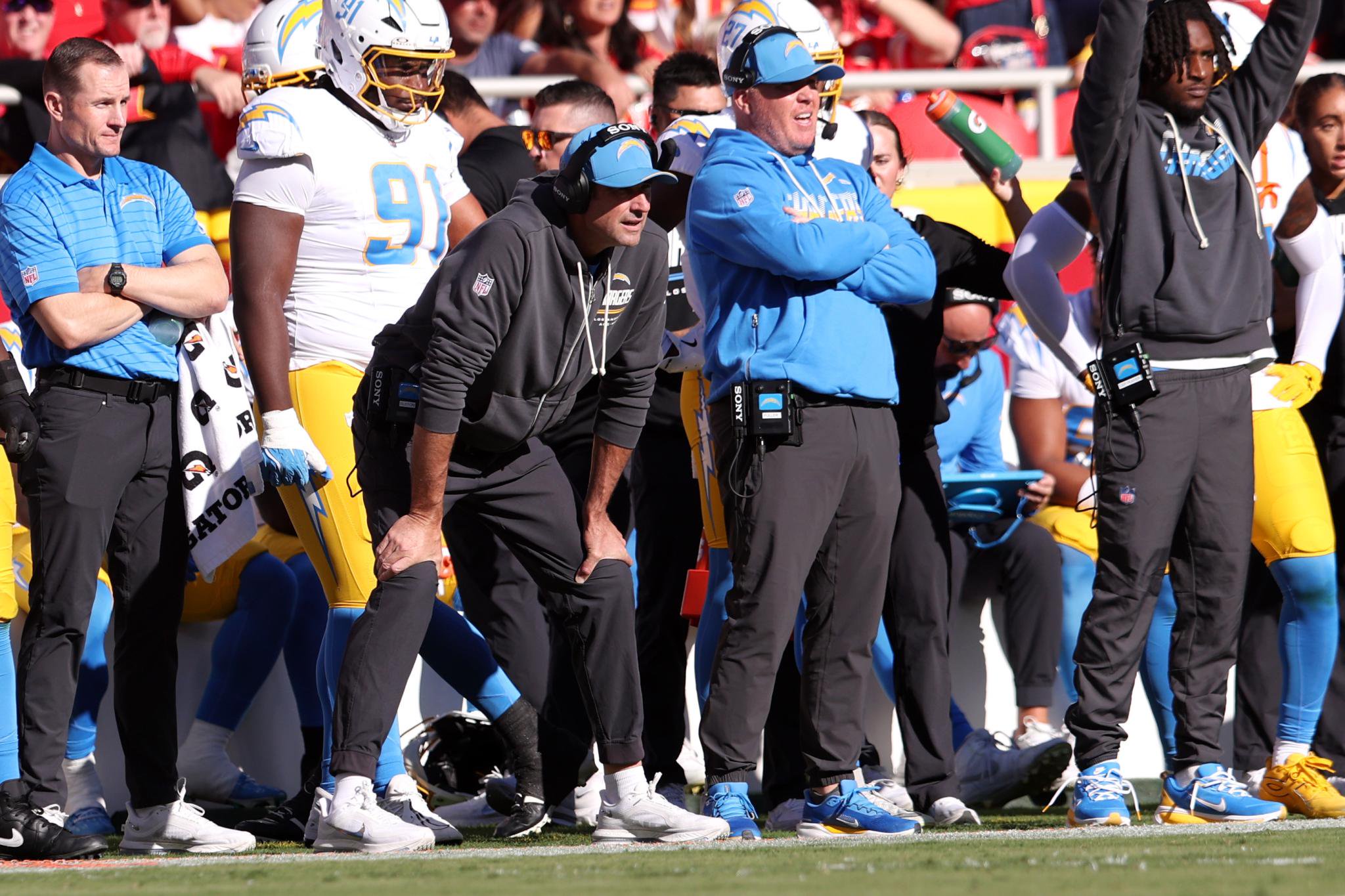 Los Angeles Chargers coaching staff and players on the sideline during a game against the Kansas City Chiefs.