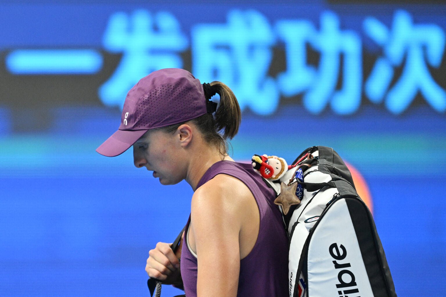 Iga Swiatek walks off the court after losing in Beijing.