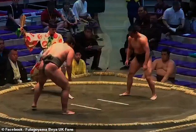 Nicholas (right) is seen here in the sumo ring before a match against his opponent