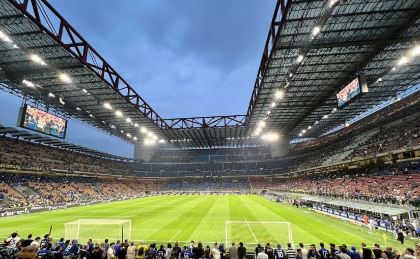 Inside San Siro under its red-trussed roof, fans gathered behind the pitch at dusk