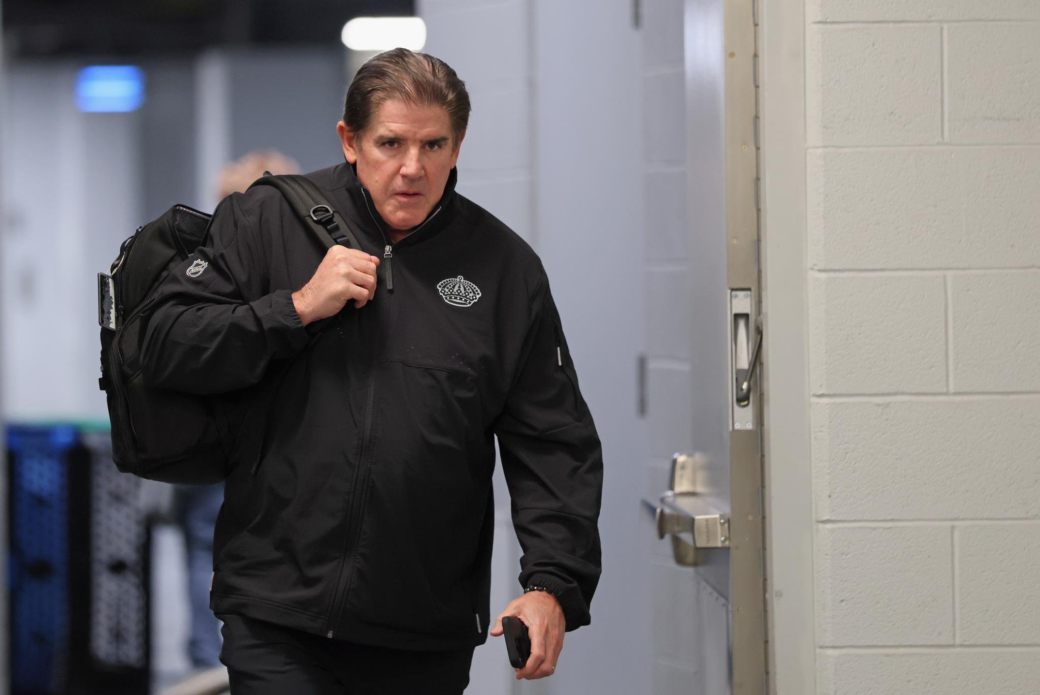 Los Angeles Kings head coach Peter Laviolette arrives at the arena carrying a bag over his shoulder.