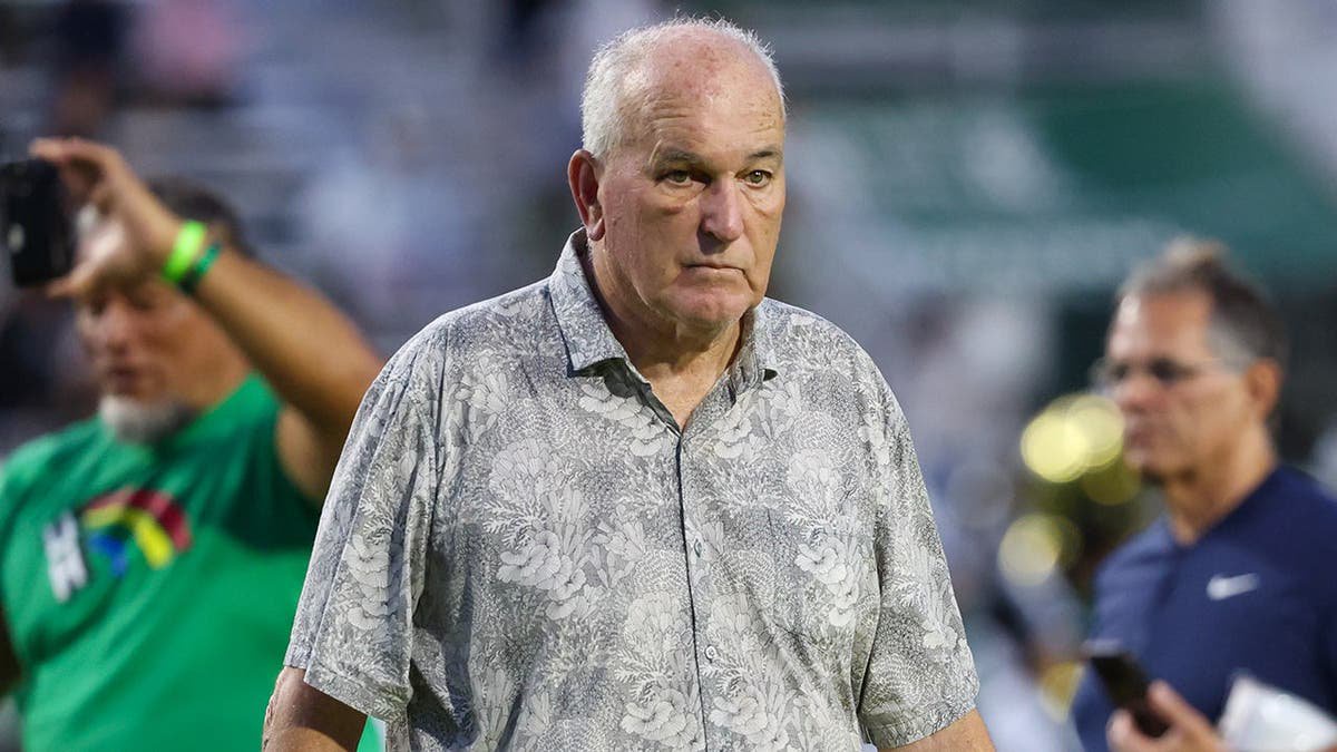 June Jones walks onto the field before a game in Honolulu.
