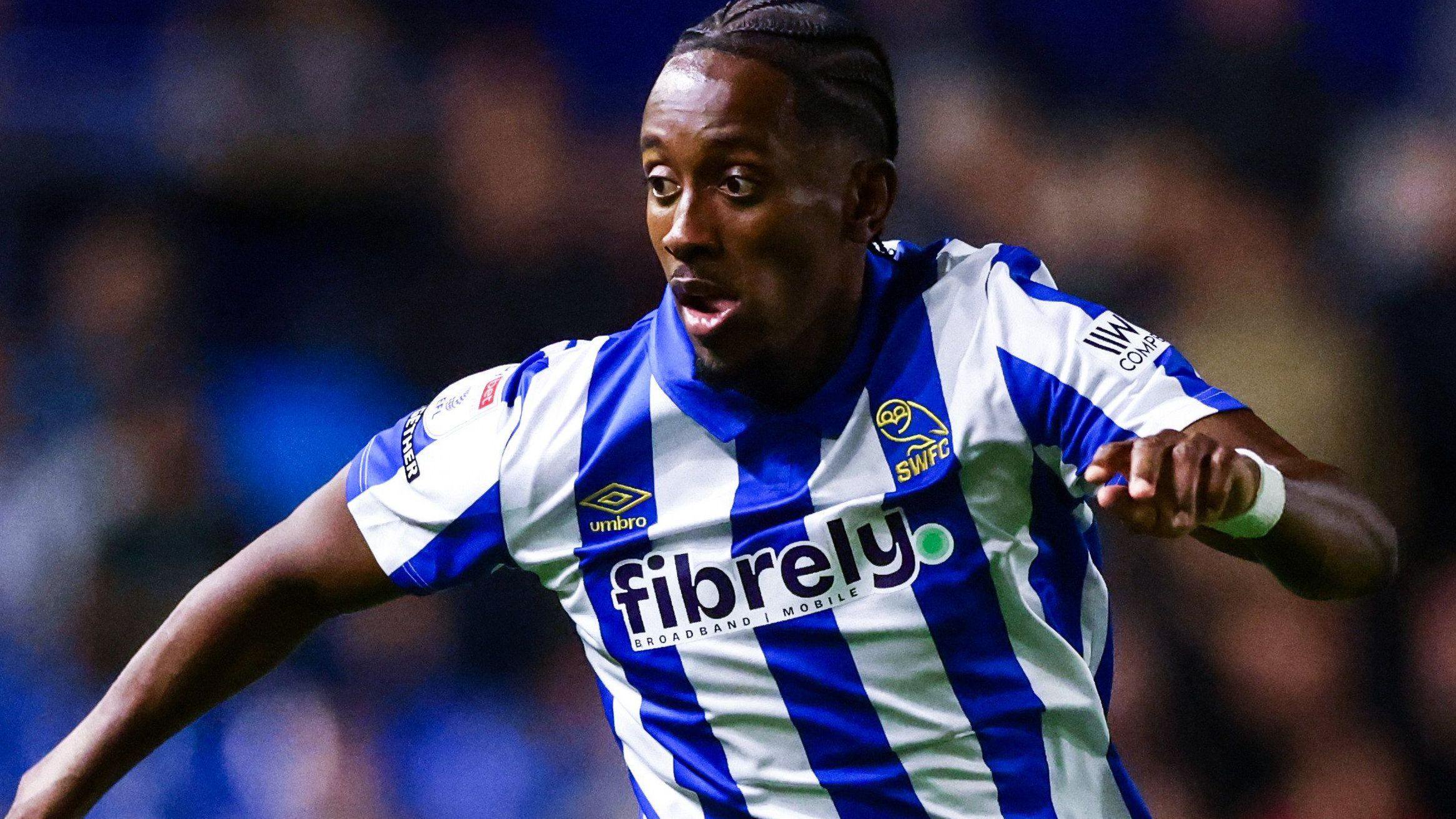 Jamal Lowe in action for Sheffield Wednesday in their blue and white striped home shirt