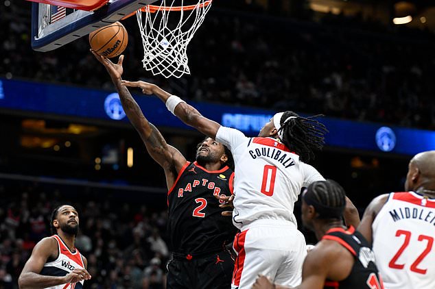 Toronto Raptors forward Kawhi Leonard (2) goes to the basket for a layup asWashington Wizards guard Bilal Coulibaly (0) defends during the first half of an NBA basketball game in Washington, Friday, Oct. 23, 2026. (AP Photo/Terrance Williams)