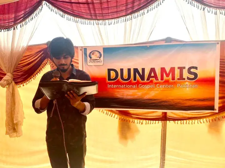 May be an image of 1 person, standing and text that says "DUNANIS DUNAMIS International Gospel Center, Pakistan"