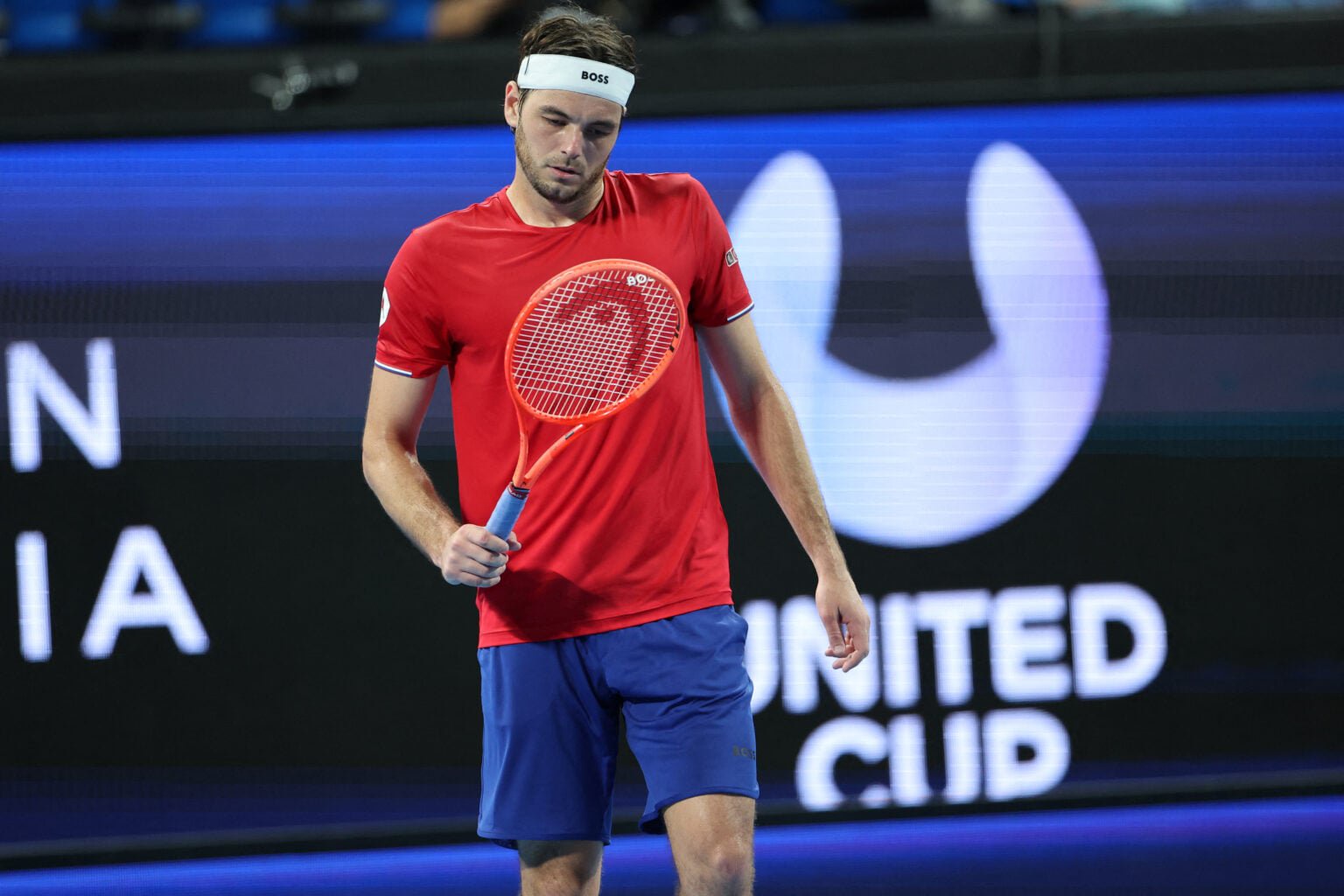 Taylor Fritz looks at his racket.