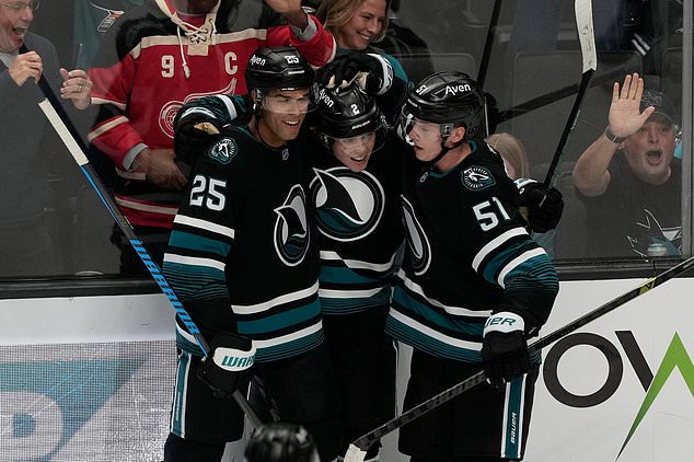 San Jose Sharks center Will Smith, middle, is congratulated by defenseman Darnell Nurse (25) and right wing Collin Graf (51) after scoring against the Vancouver Canucks during the third period of an NHL hockey game, Thursday, Oct. 29, 2026, in San Jose, Calif. (AP Photo/Jeff Chiu)
