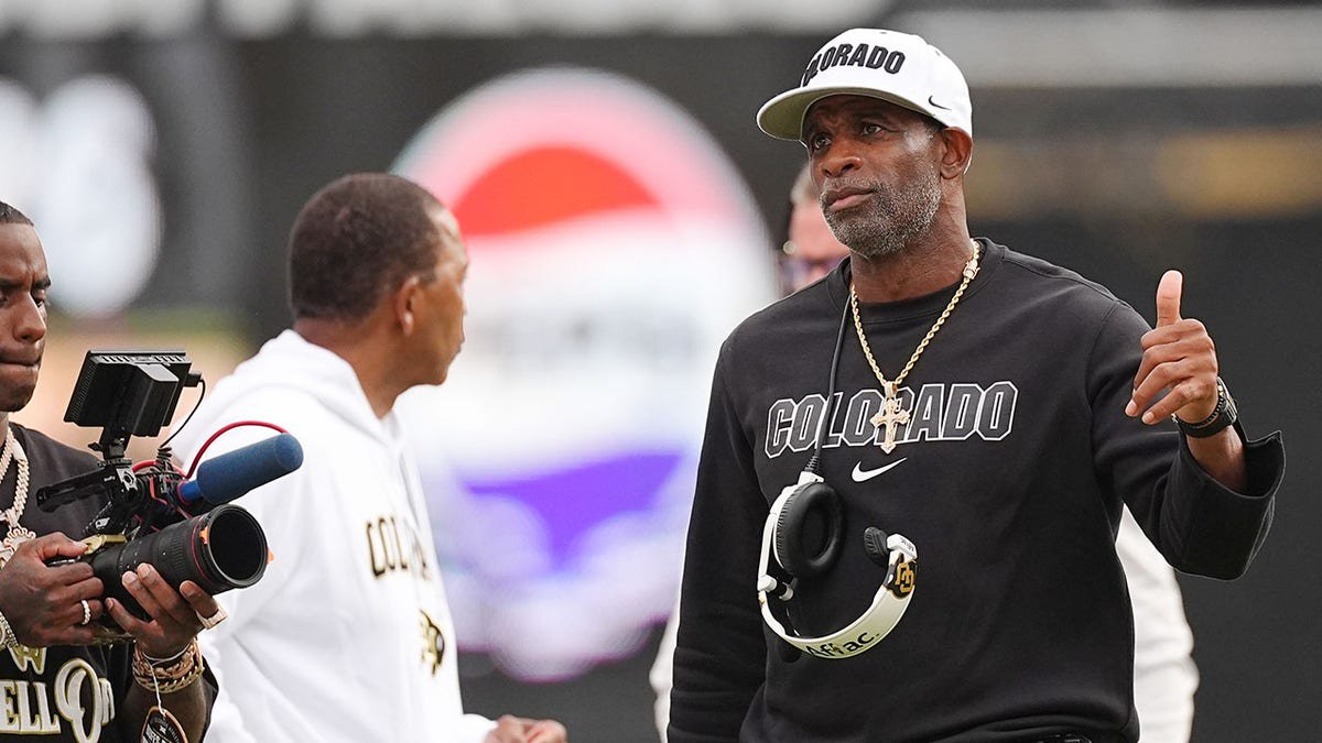 Deion Sanders gestures toward referees