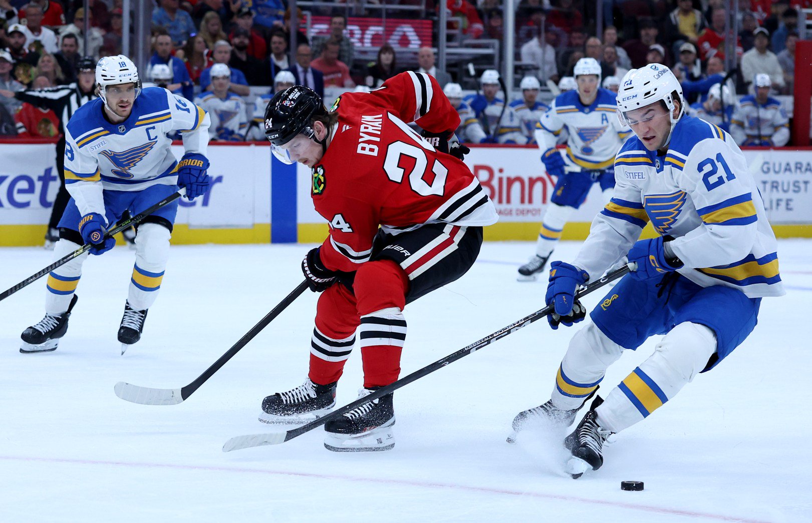Blackhawks defenseman Bowen Byram (24) and St. Louis Blues right wing Jimmy Snuggerud battle for the puck on Oct. 6, 2026, at the United Center. (Chris Sweda/Chicago Tribune)