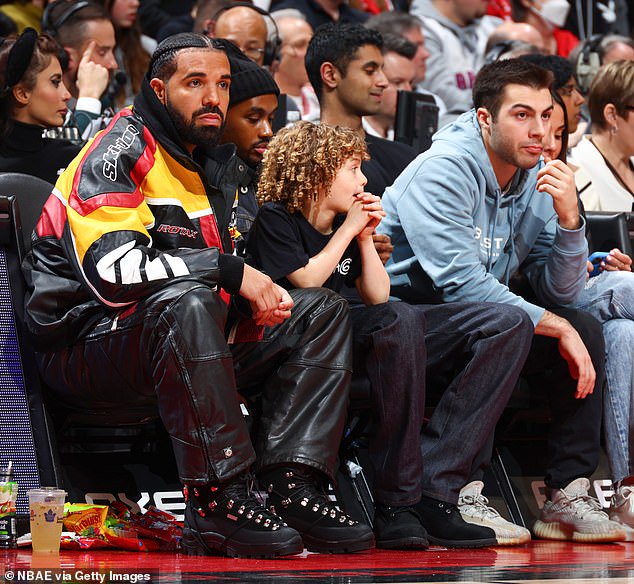 Rapper Drake embraces his son Adonis at courtside during NBA game (Photos)