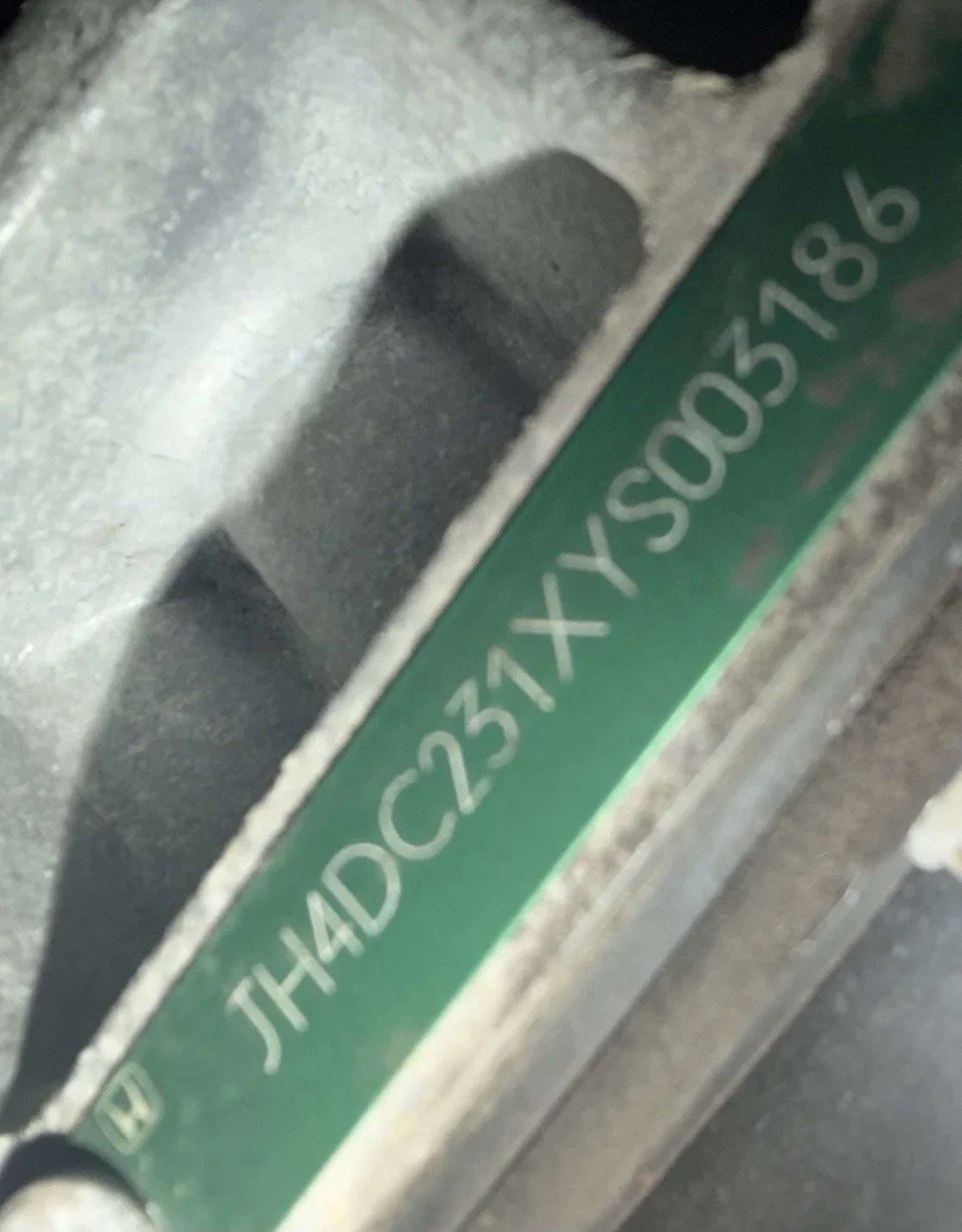 Green VIN tag on the powertrain of a 2000 Acura Integra Type R showing the JH4DC231 VIN prefix