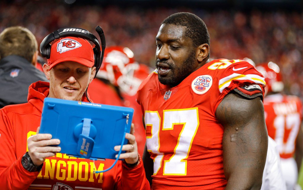 Kansas City Chiefs defensive lineman Allen Bailey looks at a tablet with defensive line coach Britt Reid during a game against the Oakland Raiders.