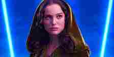Padme Amidala in a hood looking up with blue lightsabers on either side of her in front of a blue background