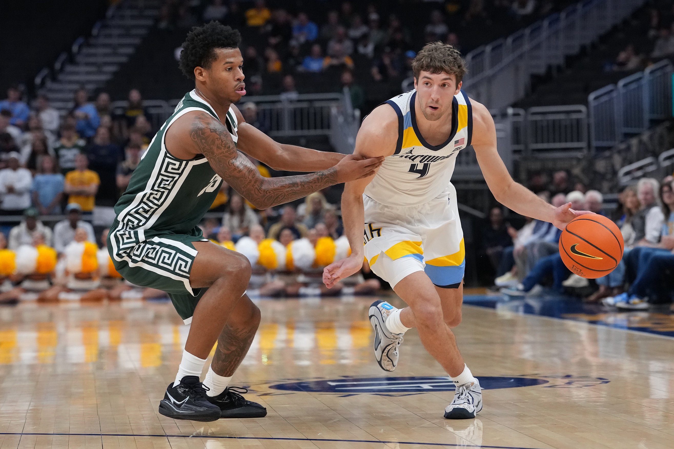 Nolan Minessale of the Marquette Golden Eagles dribbles the ball against Jasiah Jervis of the Michigan State Spartans in the first half during an exhibition game at Fiserv Forum on October 25, 2026 in Milwaukee, Wisconsin. 