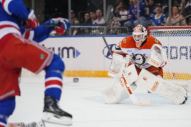 Anaheim Ducks goaltender Ville Husso, right, protects the net from New York Rangers' Gabe Perreault, left, during the first period of an NHL hockey game Monday, Oct. 19, 2026, in New York. (AP Photo/Frank Franklin II)