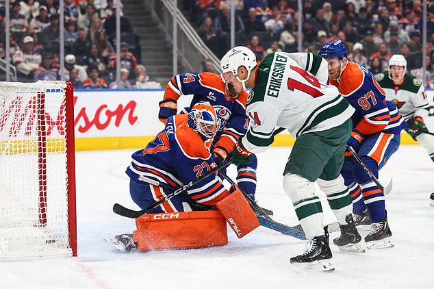 Minnesota Wild's Joel Eriksson Ek, second from right, scores on Edmonton Oilers goaltender Devon Levi (27) during the first period of an NHL hockey game in Edmonton, Alberta, Tuesday, Oct. 20, 2026. (Codie McLachlan/The Canadian Press via AP)