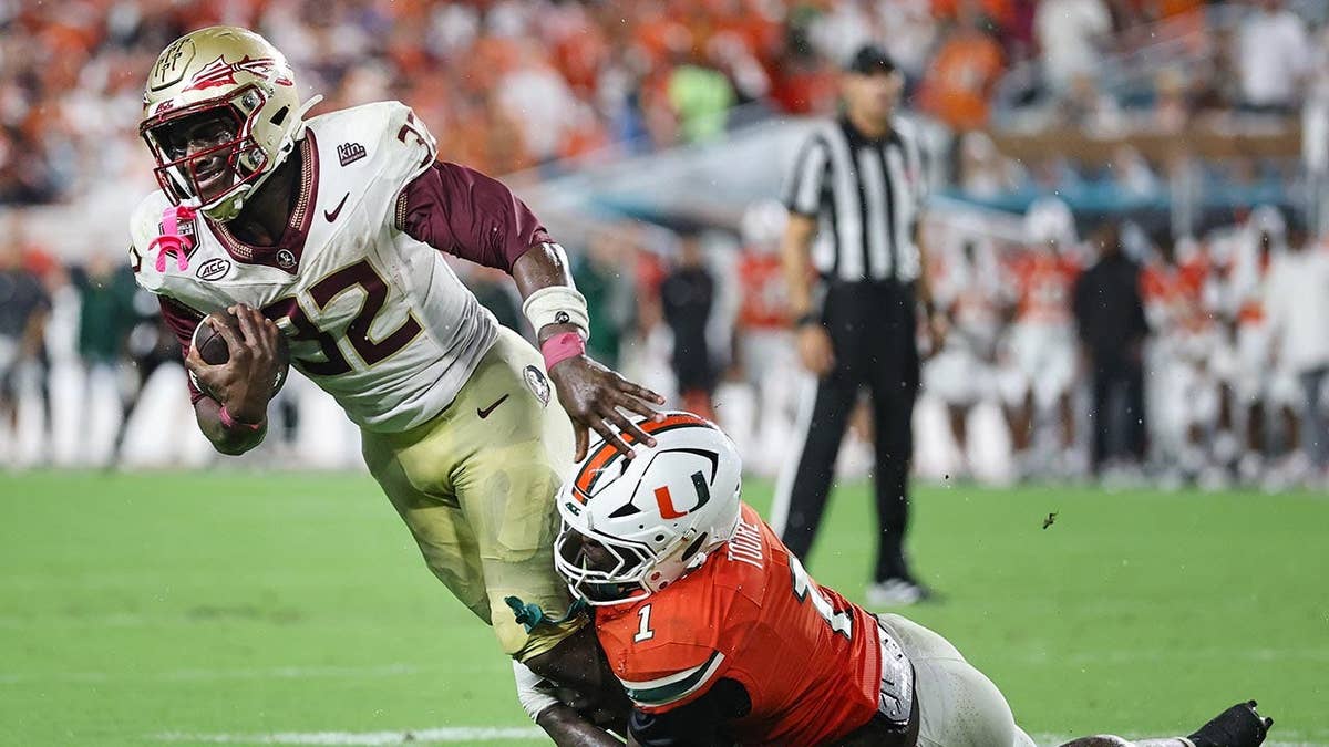 Ousmane Kromah is tackled by Mohamed Toure during a college football game