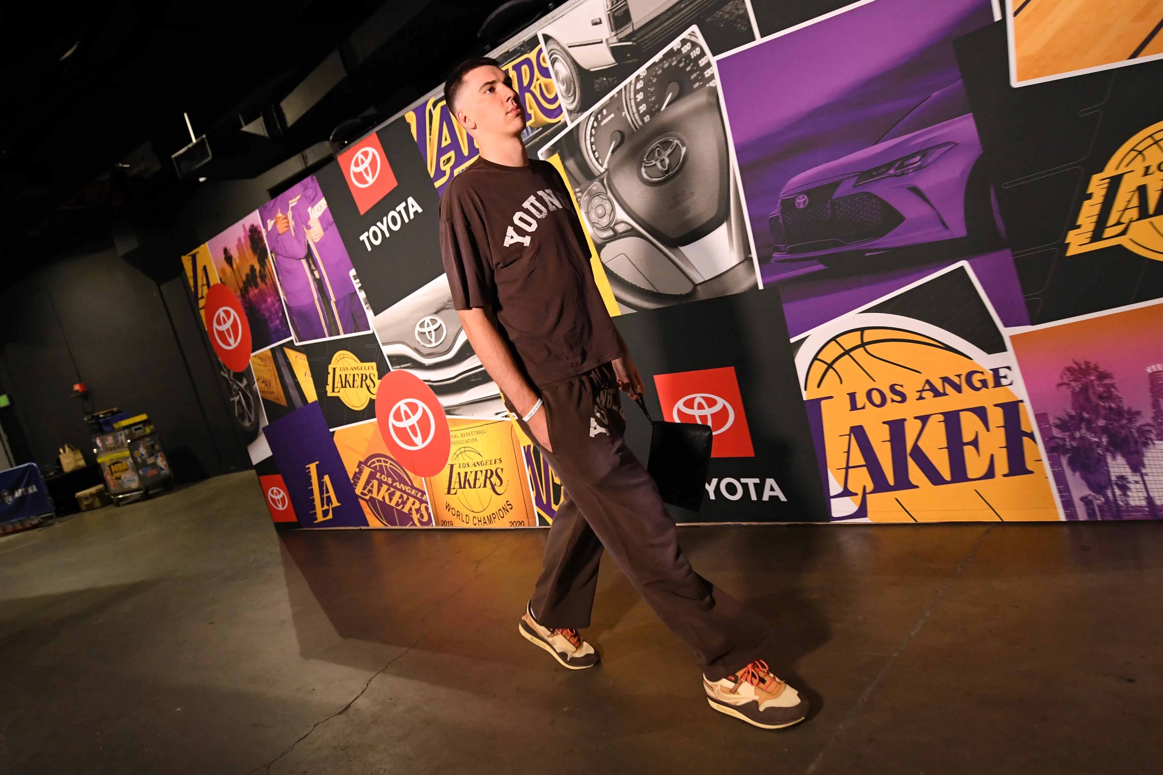 Jake LaRavia of the Los Angeles Lakers arrives to the arena in a brown t-shirt and sweatpants before a game.