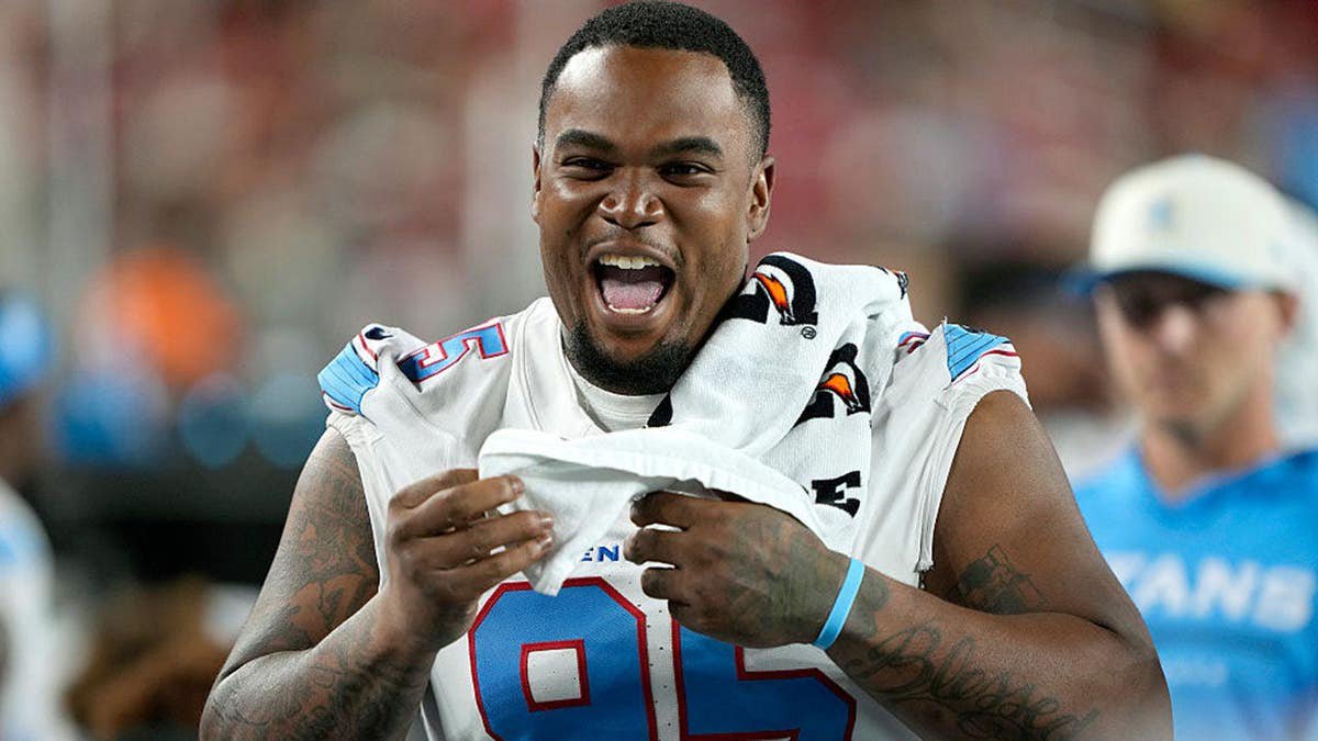 Jordan Elliott of the Tennessee Titans laughs from the sidelines during a preseason game.