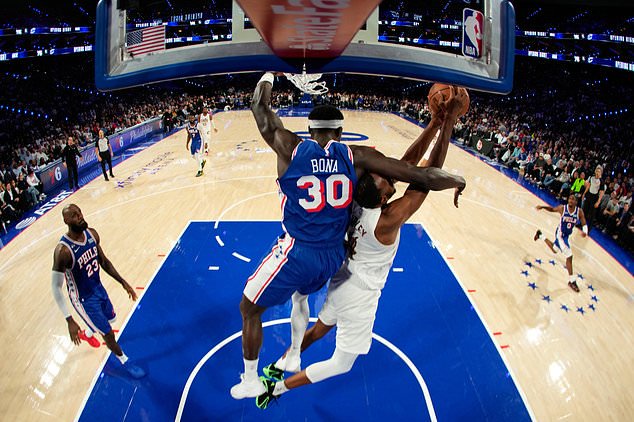 Cleveland Cavaliers' Evan Mobley, right, tries to get a shot past Philadelphia 76ers' Adem Bona during the first half of an NBA basketball game Thursday, Oct. 22, 2026, in Philadelphia. (AP Photo/Matt Slocum)