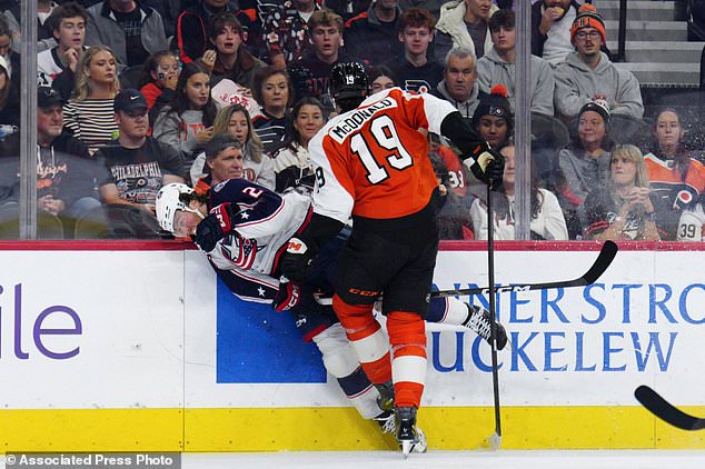 Philadelphia Flyers' Hunter McDonald (19) checks Columbus Blue Jackets' Jake Christiansen during the second period of an NHL hockey game, Tuesday, Oct. 27, 2026, in Philadelphia. (AP Photo/Derik Hamilton)