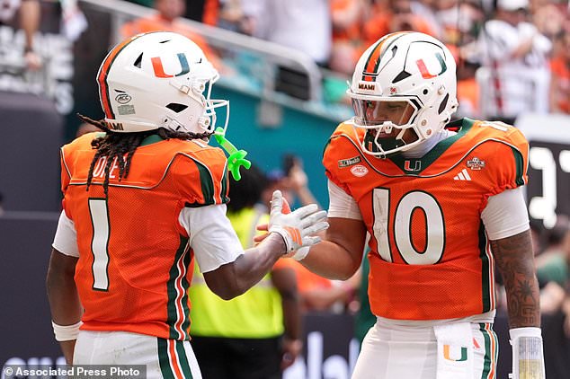 Miami wide receiver Malachi Toney (1) celebrates with quarterback Darian Mensah (10) after scoring a touchdown against Pittsburgh during the first half of an NCAA college football game, Saturday, Oct. 24, 2026, in Miami Gardens, Fla. (AP Photo/Rebecca Blackwell)