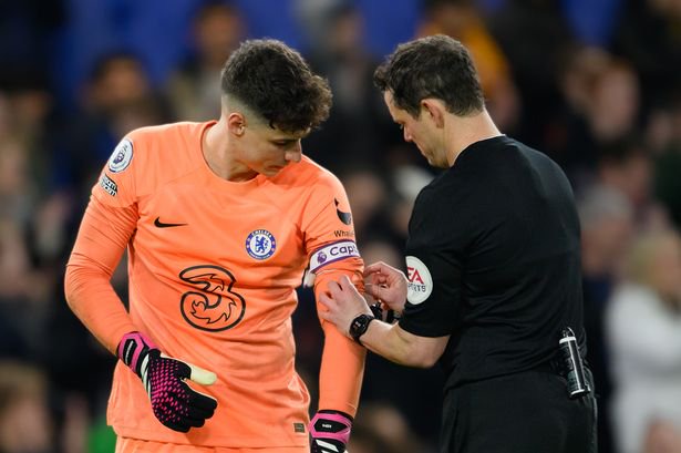 Referee Darren England (right) adjusting the Captain armband on Chelsea's Kepa Arrizabalaga (left) during the Premier League match between Chelsea FC and Everton FC at Stamford Bridge on March 18, 2023 in London, United Kingdom.