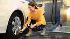 Woman in yellow checking tire pressure