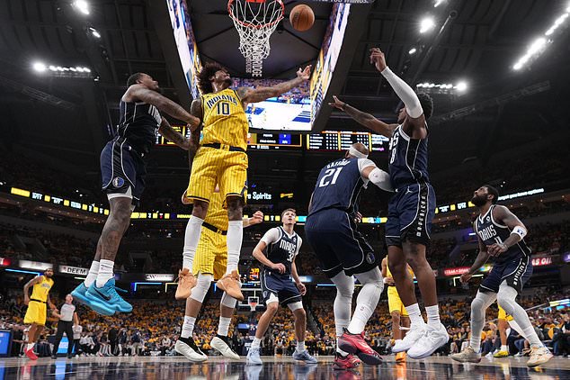 Indiana Pacers forward-guard Kelly Oubre Jr. (10) shoots against a group of Dallas Maverick defenders in the first half of an NBA basketball game in Indianapolis, Friday, Oct. 23, 2026. (AP Photo/AJ Mast)