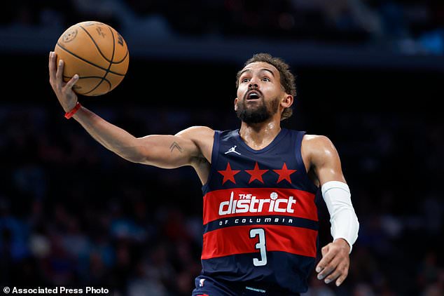 Washington Wizards guard Trae Young drives to the basket for a layup against the Charlotte Hornets during the second half of an NBA basketball game in Charlotte, N.C., Monday, Oct. 26, 2026. (AP Photo/Nell Redmond)