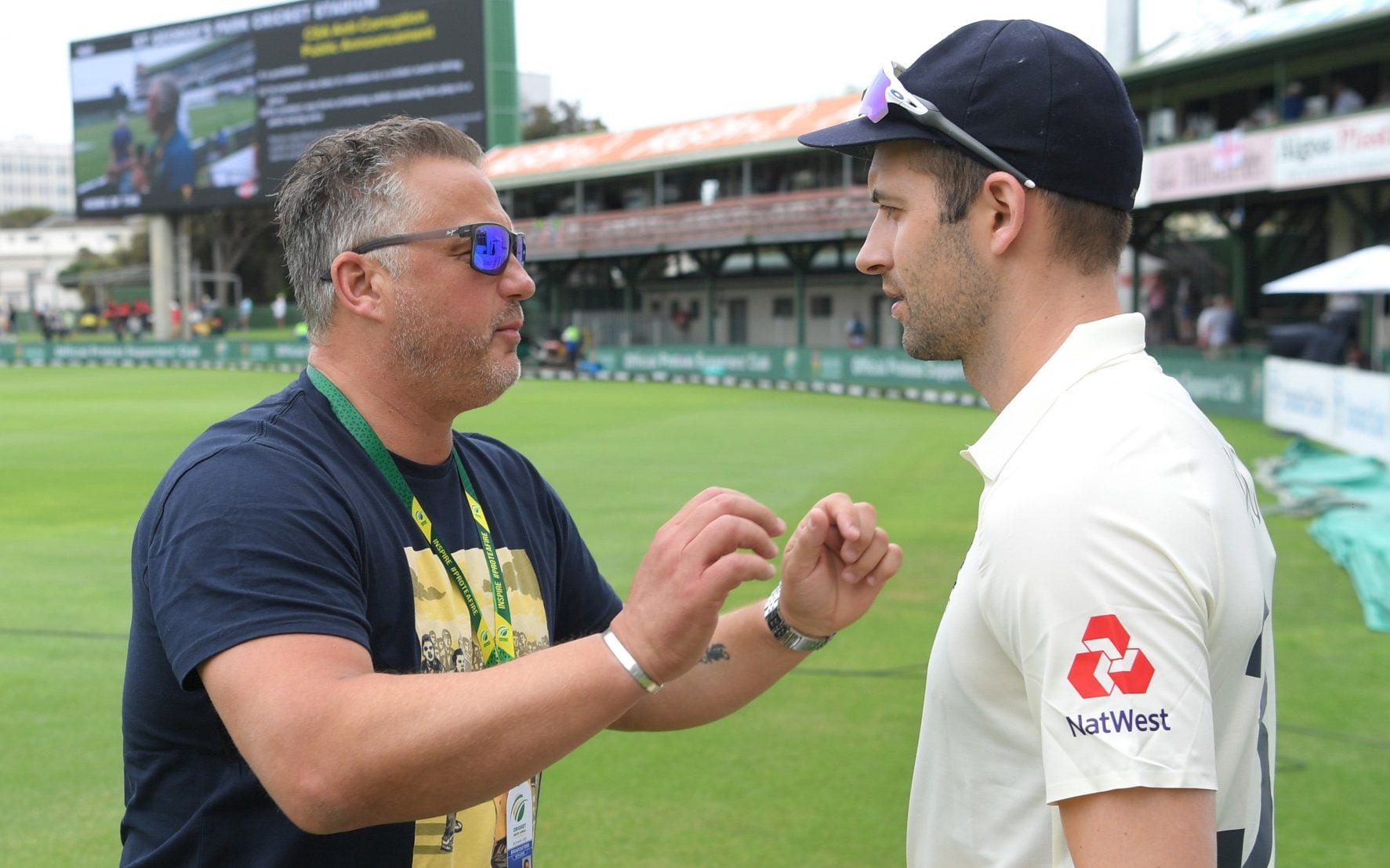 Mark Wood of England listens to former player and TalkSport commentator Darren Gough