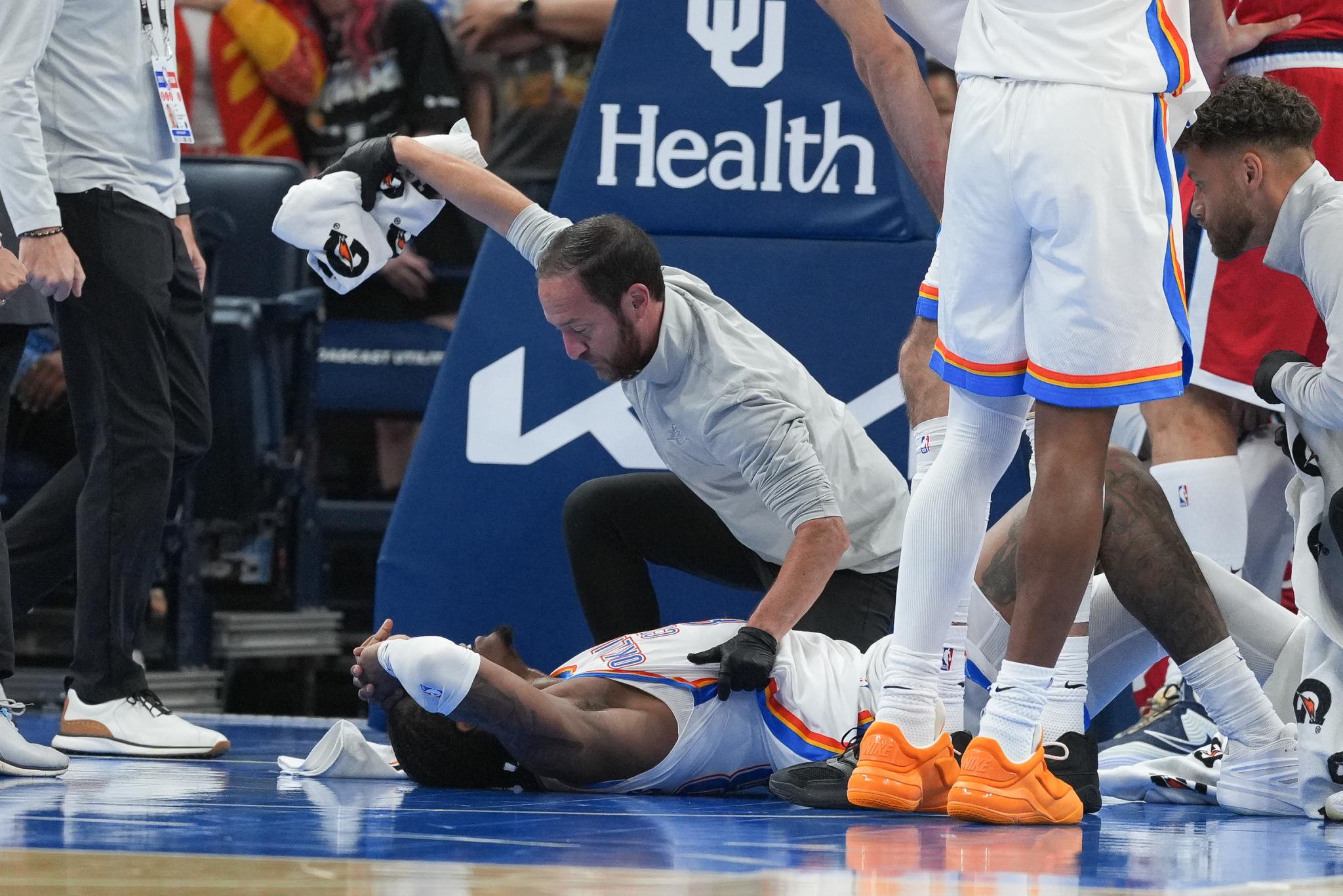 Oklahoma City Thunder guard Jalen Williams is attended to by medical staff on the court during a game.