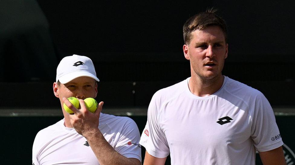 Harri Heliovaara and Henry Patten discuss tactics during the Wimbledon men's doubles final in July 2026