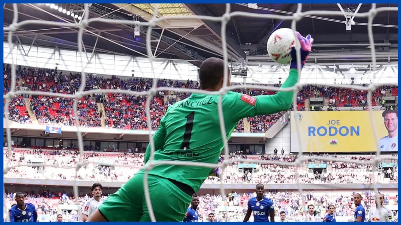 Robert Sanchez in a green goalkeeper kit making a save during a match.