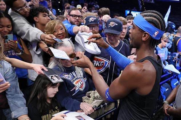 Oklahoma City Thunder guard Shai Gilgeous-Alexander, right, signs autographs for fans before an NBA basketball game against the Denver Nuggets, Thursday, Oct. 22, 2026, in Oklahoma City. (AP Photo/Nate Billings)