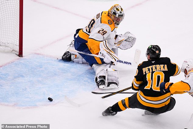 Boston Bruins' JJ Peterka (10) scores against Nashville Predators' Justus Annunen (29) during the second period of an NHL hockey game, Thursday, Oct. 22, 2026, in Boston. (AP Photo/Charles Krupa)