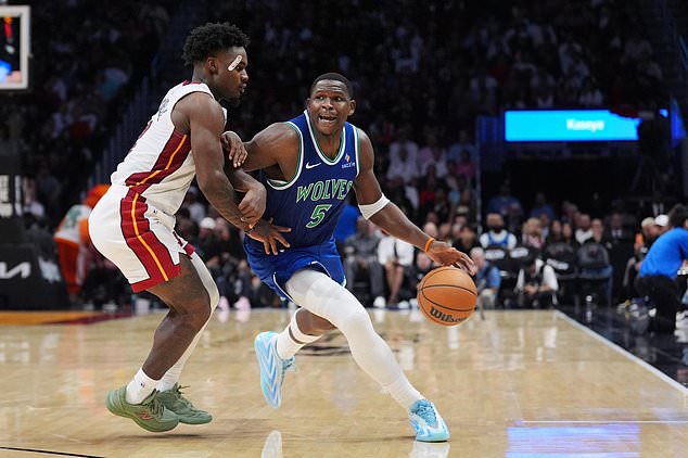 Minnesota Timberwolves guard Anthony Edwards (5) drives past Miami Heat guard Davion Mitchell during the second half of an NBA basketball game, Wednesday, Oct. 21, 2026, in Miami. (AP Photo/Rebecca Blackwell)