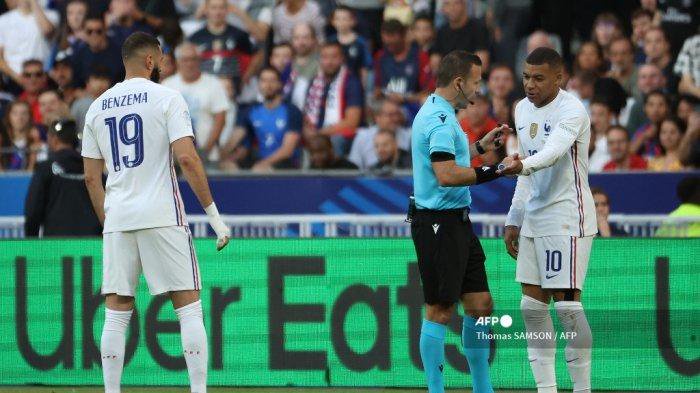 Pemain depan Prancis Kylian Mbappe (kanan) berdebat dengan wasit Israel Orel Grinfeld (tengah) setelah bersiul penalti untuk Kroasia, melewati pemain depan Prancis Karim Benzema selama pertandingan sepak bola UEFA Nations League - Liga A Grup 1 antara Prancis dan Kroasia di Stade de France di Saint-Denis, di pinggiran Paris pada 13 Juni 2022.
