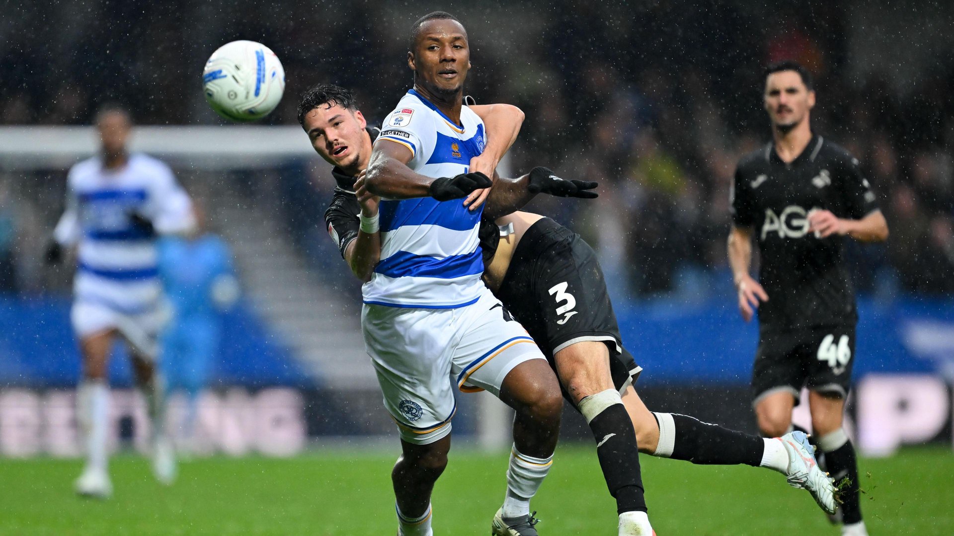 Richard Kone (front) of Queens Park Rangers is held by Swansea City's Jenson Seelt as he runs for the ball during their Championship match on Saturday