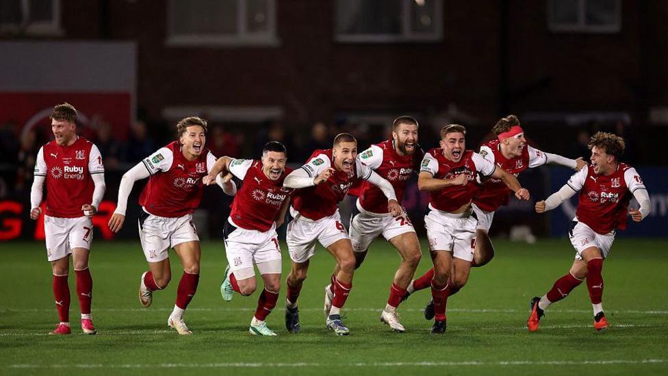 Fleetwood Town players celebrate their keeper saving a goal in the penalty shootout against Arsenal