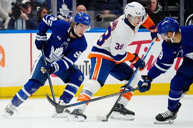 Toronto Maple Leafs' Gavin McKenna (92) chases New York Islanders' Victor Eklund (38) during the first period of an NHL hockey game in Toronto, Saturday, Oct. 17, 2026. (Frank Gunn/The Canadian Press via AP)