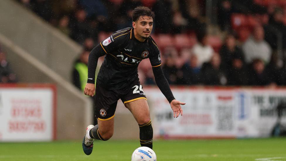 Newport County's Matt Dibley-Dias wearing a full kit of black and amber trims during a fixture against Cheltenham Town.
